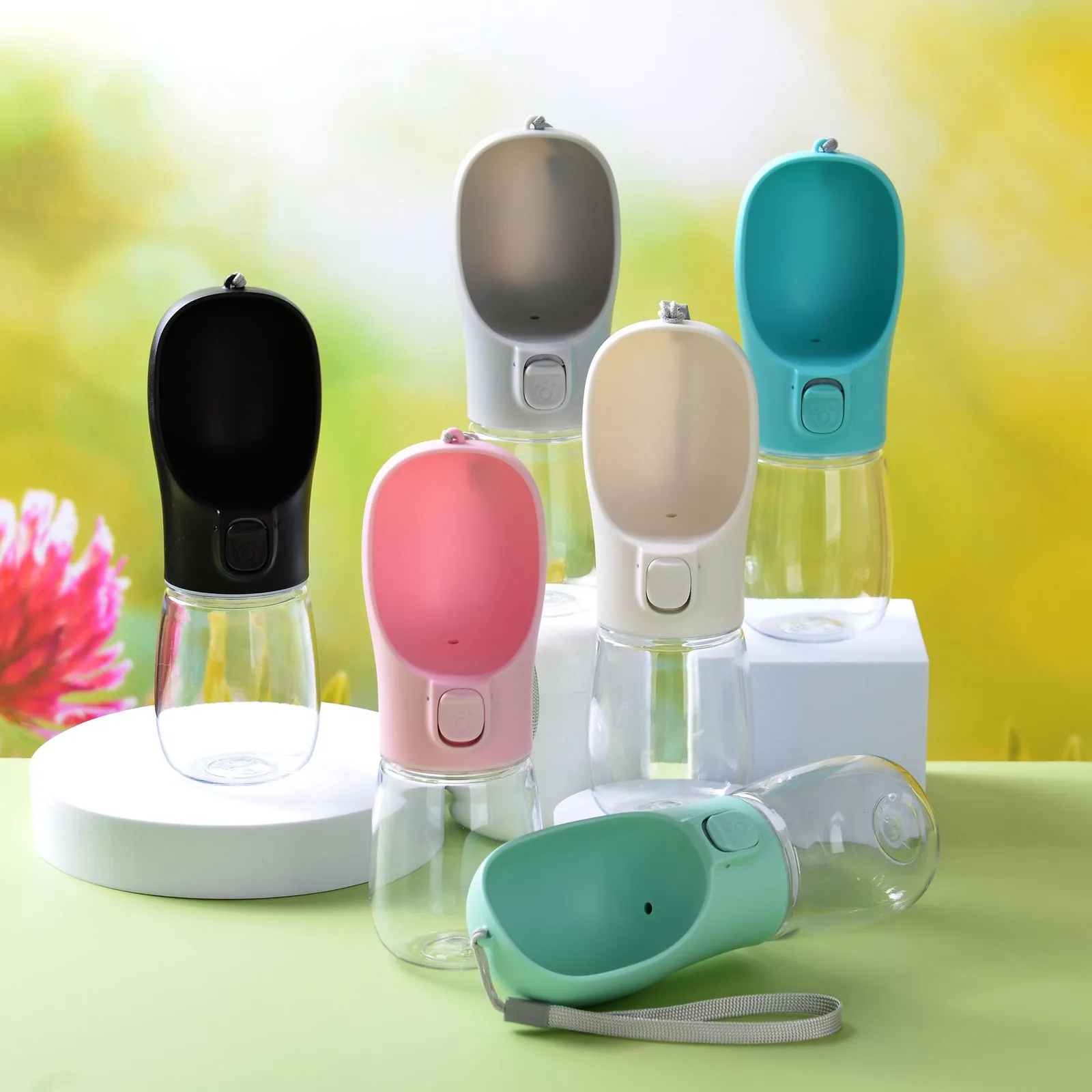 Collection of portable pet water bottles in black, pink, beige, grey, teal, and mint green.