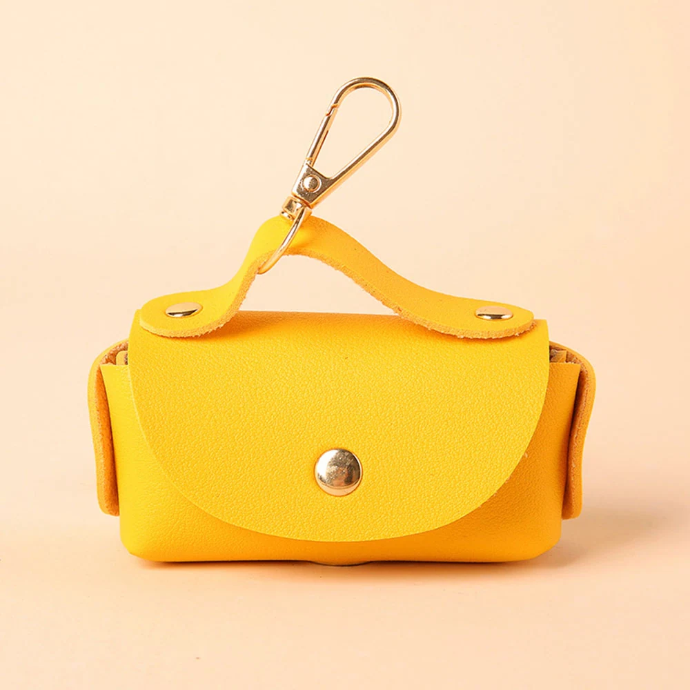 Small yellow leather pouch with a metal clasp and keyring on a plain background