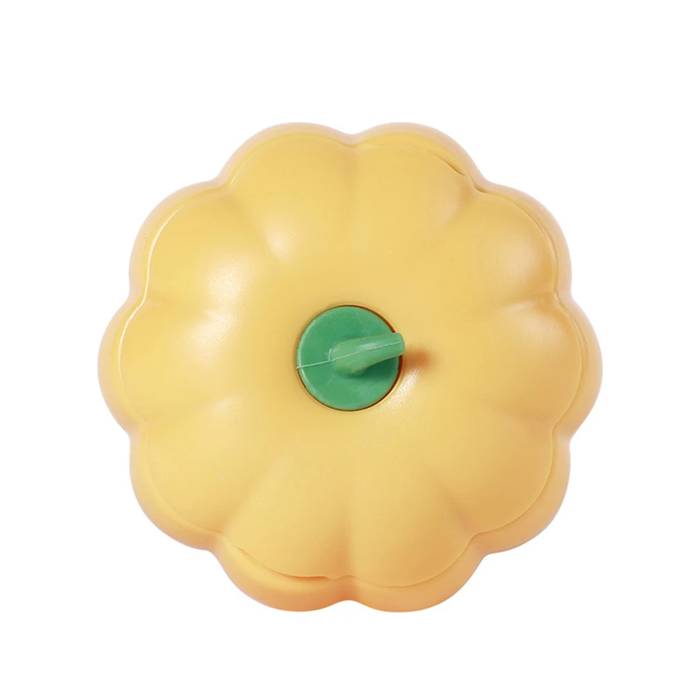 Top-down view of a yellow, flower-shaped plastic container with a green center.