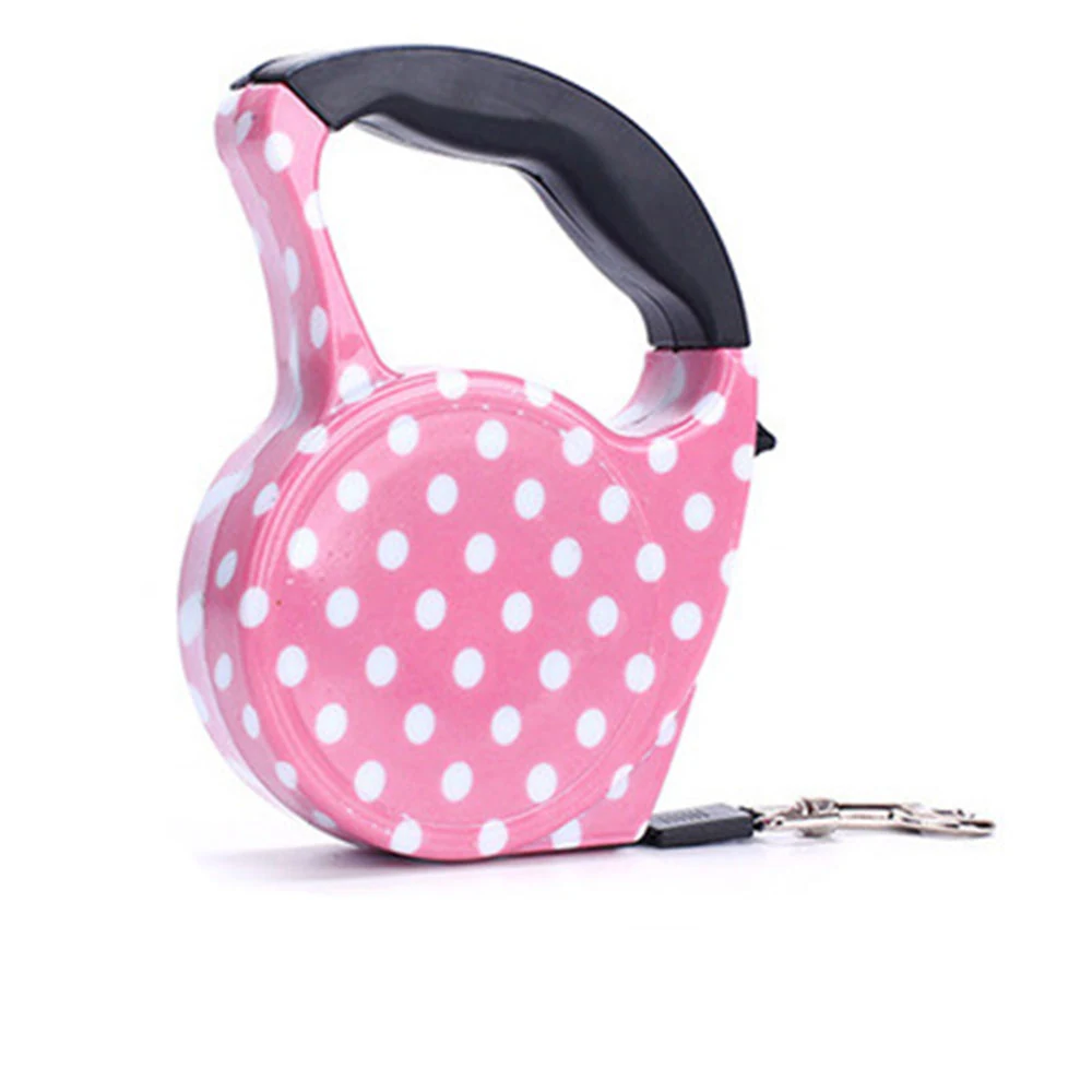Pink retractable dog leash with white polka dots and black handle