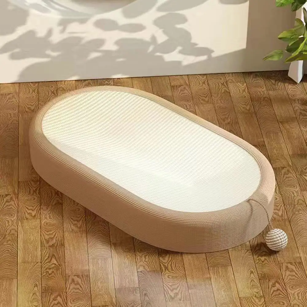 Beige and white oval pet bed with a sisal ball attached, resting on a wooden floor.