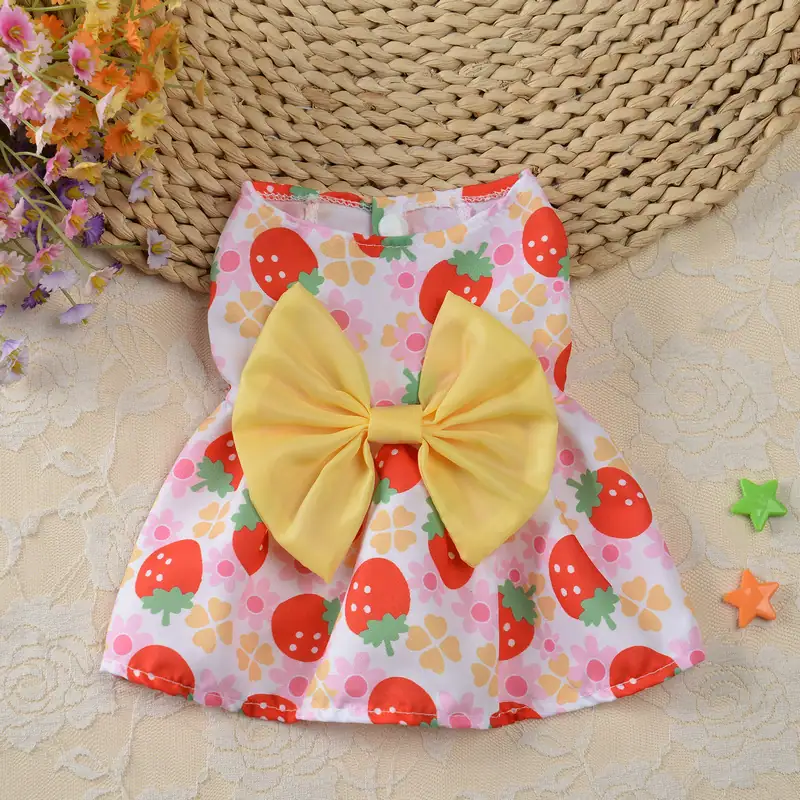 Pink sleeveless pet dress with strawberry pattern and large yellow bow