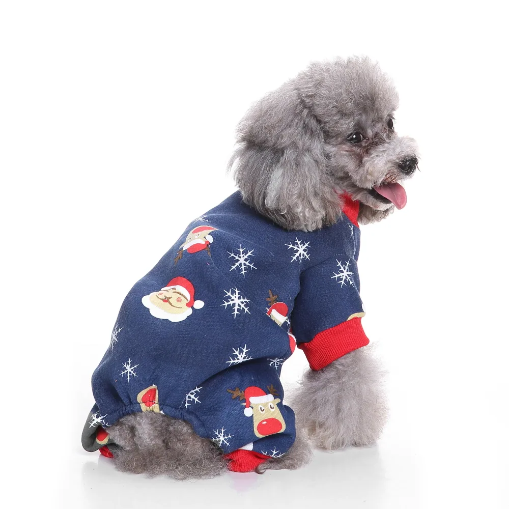 A grey poodle sitting in profile wearing a blue Christmas-themed outfit with red cuffs and festive prints.