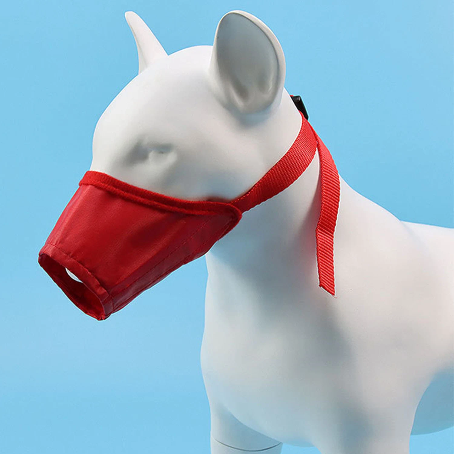 Red dog muzzle displayed on a white mannequin head against a blue background