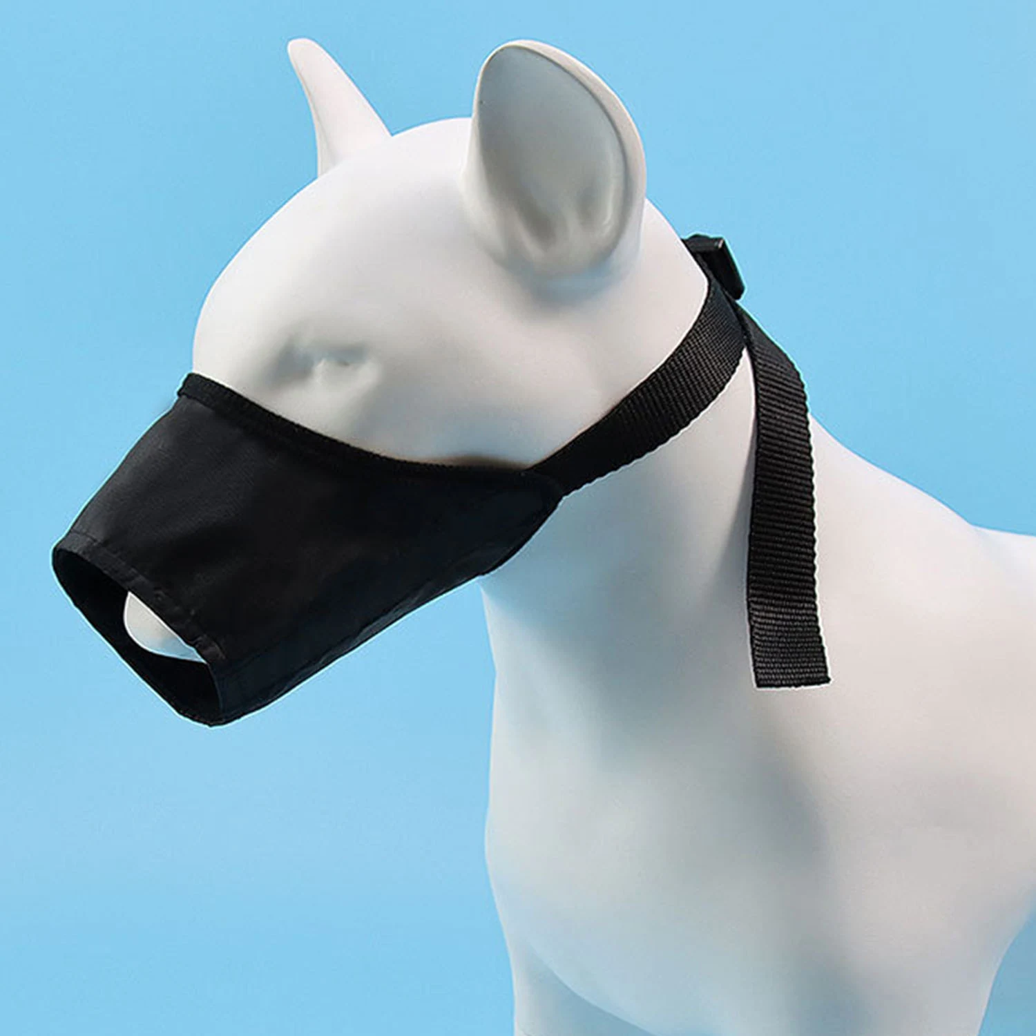 Black dog muzzle displayed on a white mannequin head against a blue background