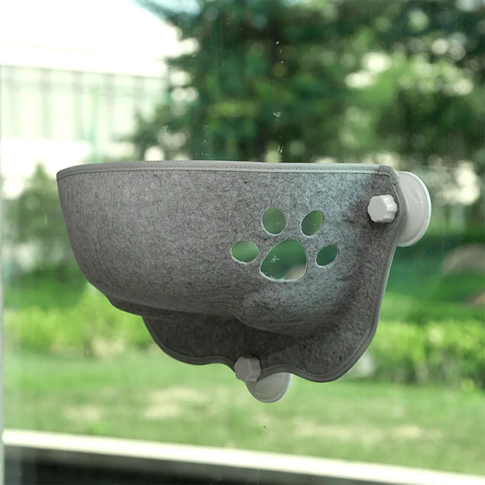 Gray felt pet window perch with paw print cutout attached to glass