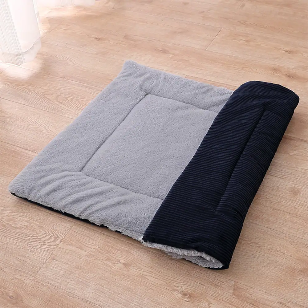 Grey and black reversible pet mat lying on a wooden floor