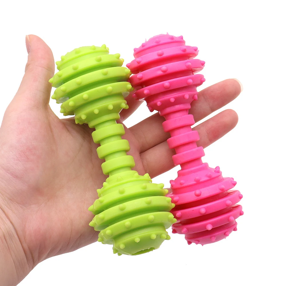 Hand holding green and pink spiky dumbbell-shaped massage rollers