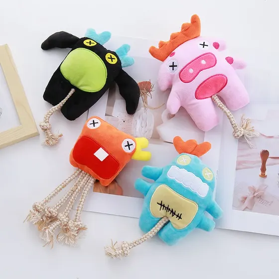 Four colorful plush monster toys with rope tails arranged on a white surface