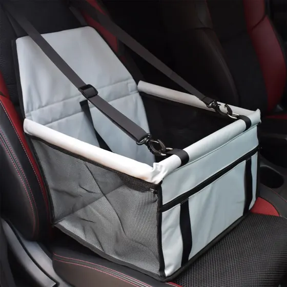 Light grey car seat booster with safety straps installed on a vehicle seat