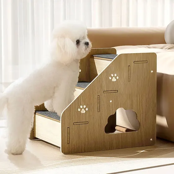 White dog using wooden pet stairs to climb onto a sofa