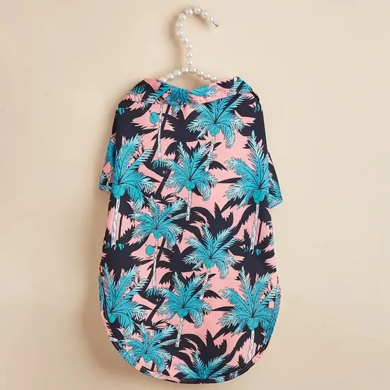 Pink pet shirt with blue palm tree print hanging on a beaded hanger