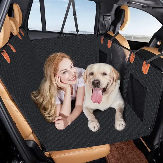Woman and Labrador dog resting on black quilted car seat cover in the back seat of a vehicle.