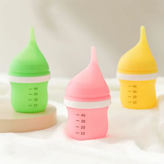 Three silicone baby food squeeze bottles in green, pink, and yellow with measurement markings.