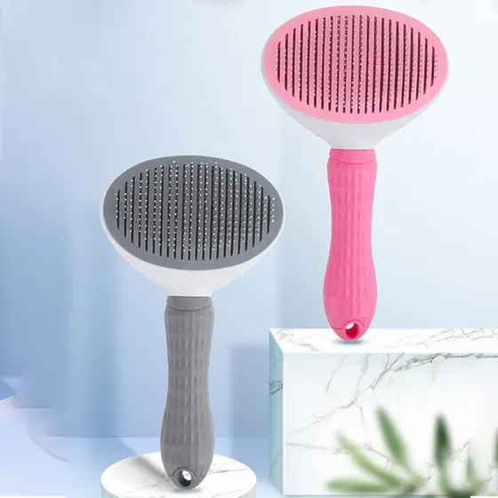Two oval grooming brushes, one pink and one gray, displayed on white marble pedestals.