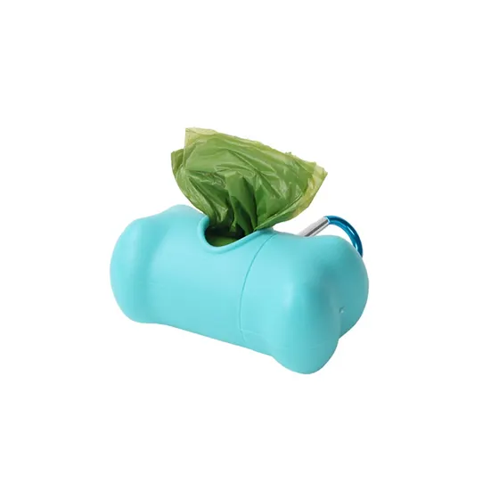 Teal plastic bone-shaped bag dispenser with a green plastic bag protruding from the top slot and a blue carabiner attached.