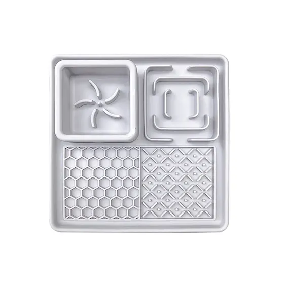White plastic divided food tray featuring four compartments with star, square, honeycomb, and geometric textured patterns.