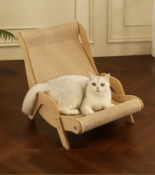 A white cat resting on a wooden sisal cat lounger chair on a parquet floor.