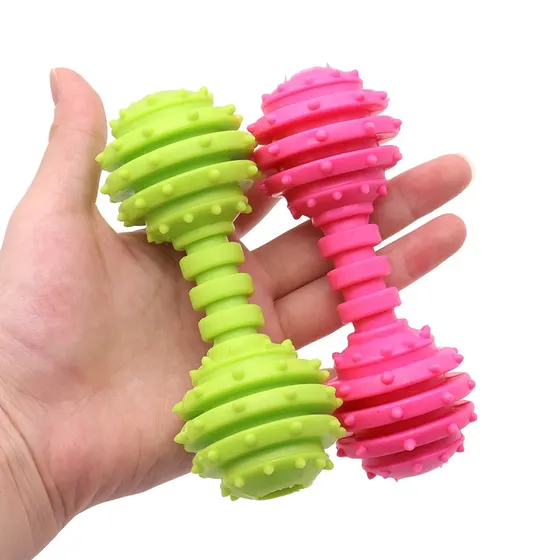 Hand holding green and pink spiky dumbbell-shaped massage rollers