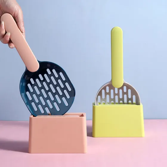 Two pastel-colored cat litter scoops with storage bases, one pink and one yellow, against a blue and pink background.