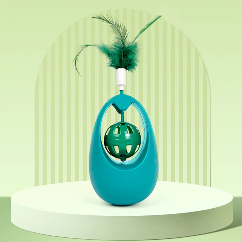Teal plastic cat toy with a suspended green ball and feather attachment, standing on a white pedestal.