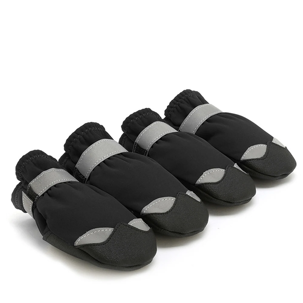Set of four black and grey dog boots with reflective straps on a white background