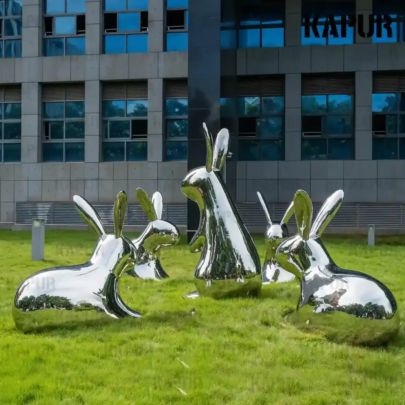 Second view of the polished stainless steel rabbit sculpture showing the curved reflective surface and detailed form