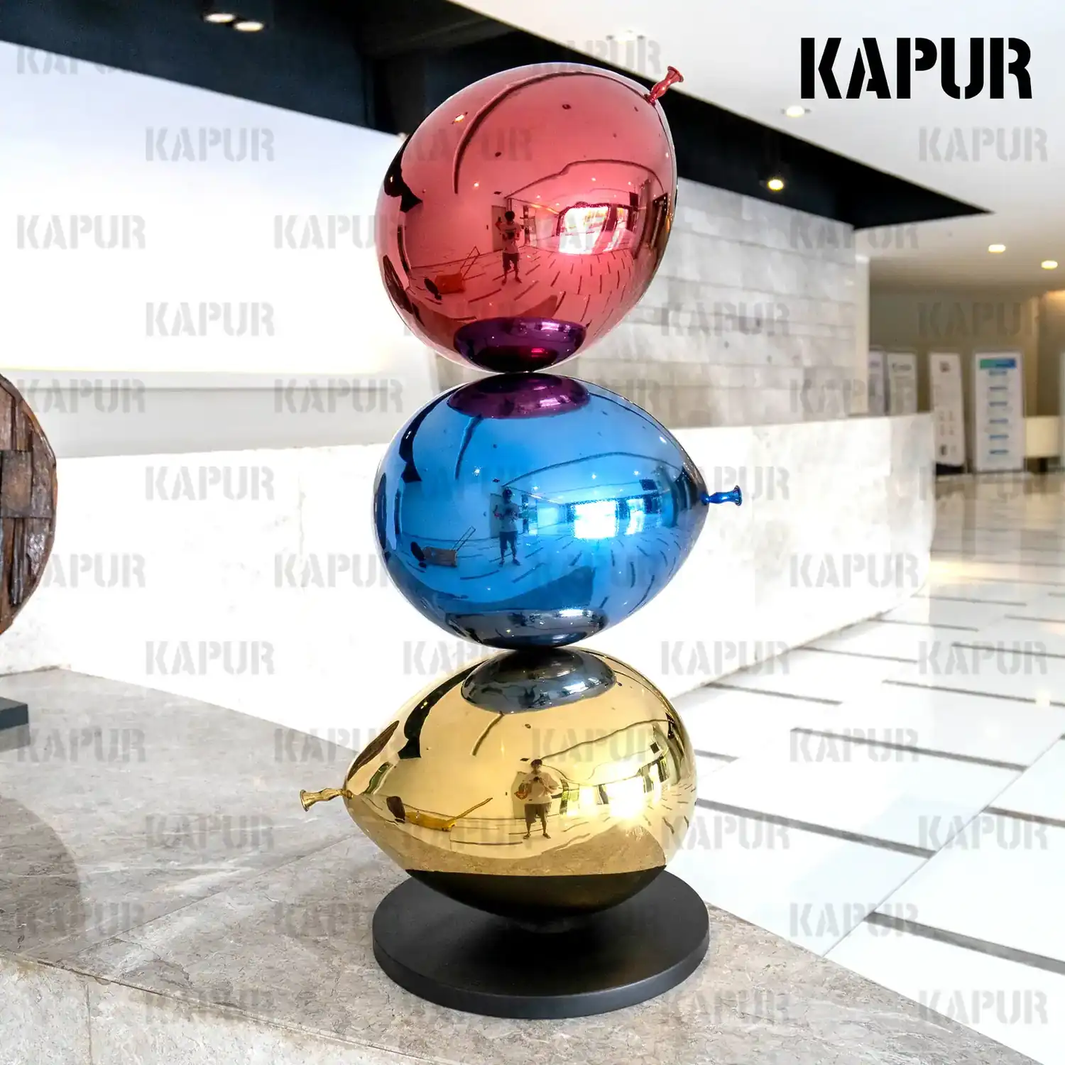 Second view of the tricolor balloon sculpture showing the curved reflective surface and color variation