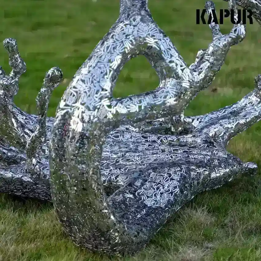 Second view of the abstract stainless steel sculpture showing the curved reflective surface and polished finish