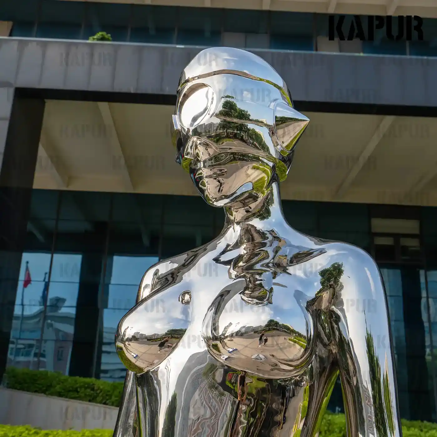 Side view of the abstract woman sculpture showing the curved reflective surface and flowing form
