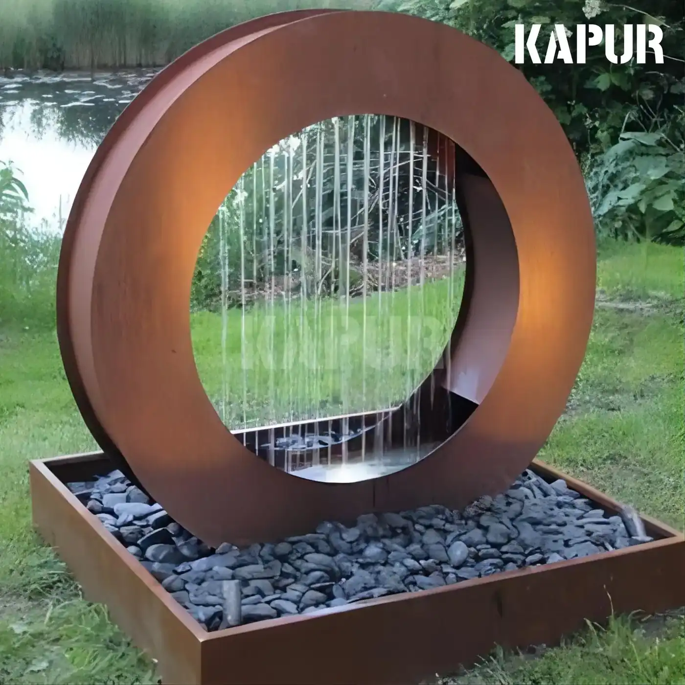 Corten steel round water portal sculpture with a waterfall feature in an outdoor garden setting
