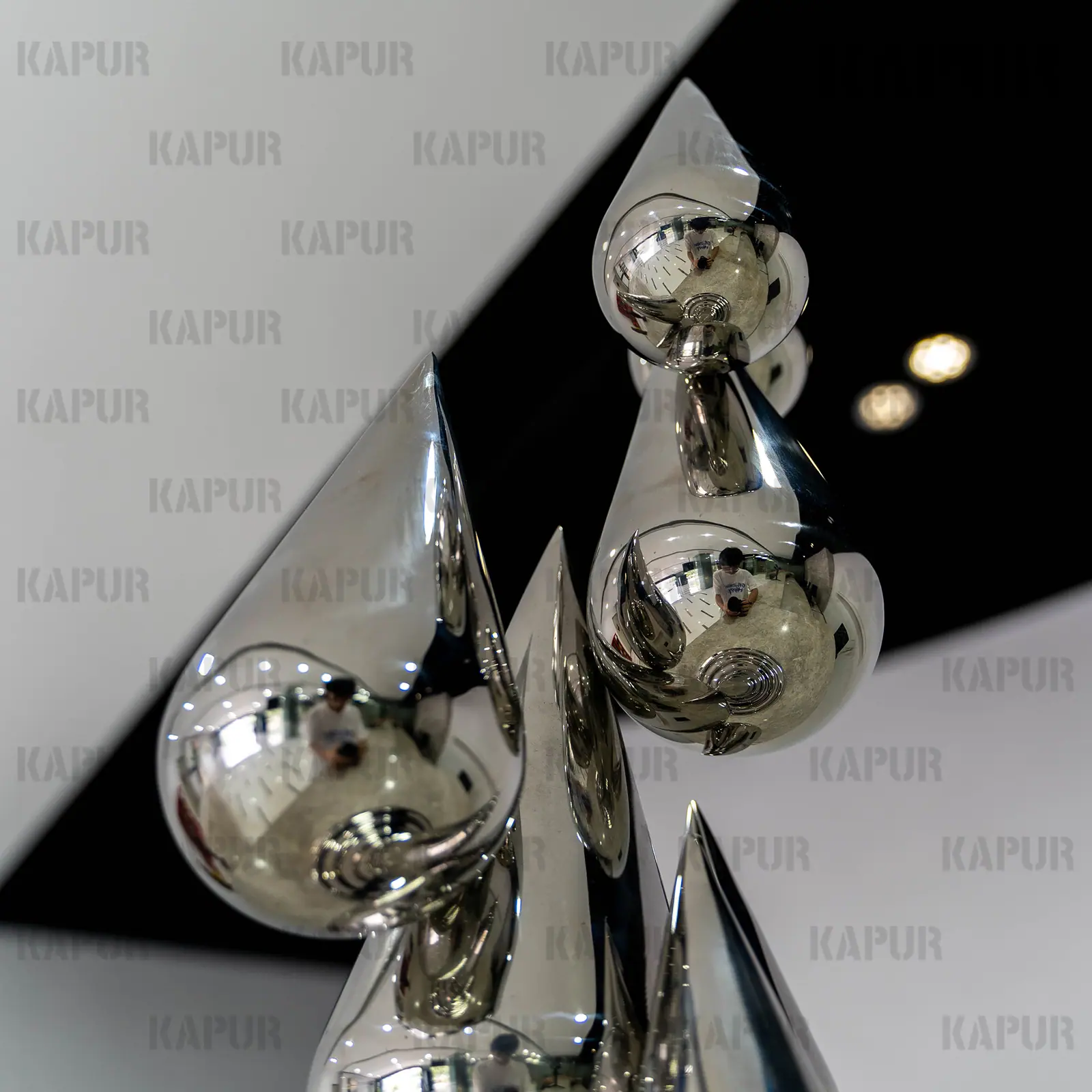 Second view of the water drop sculpture showing the curved reflective surface and seamless welds