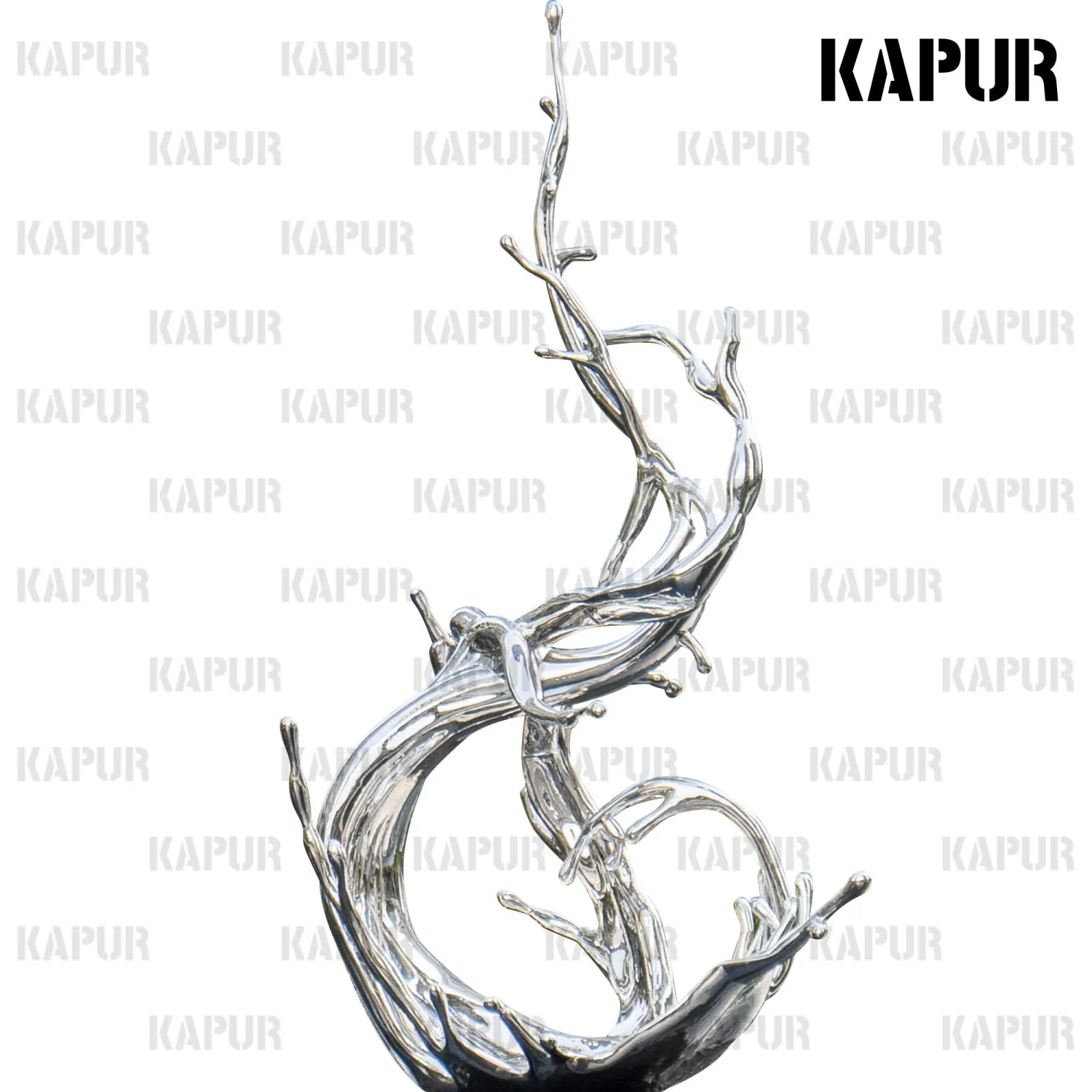 Polished stainless steel water flowers sculpture standing on a paved outdoor plaza with reflective surface catching sunlight