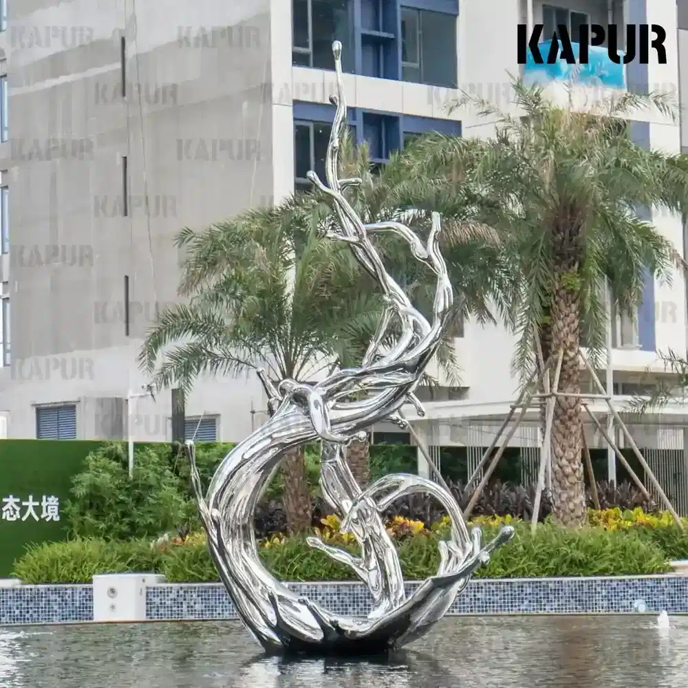Second view of the water flowers sculpture showing the curved reflective surface and flowing form from the side
