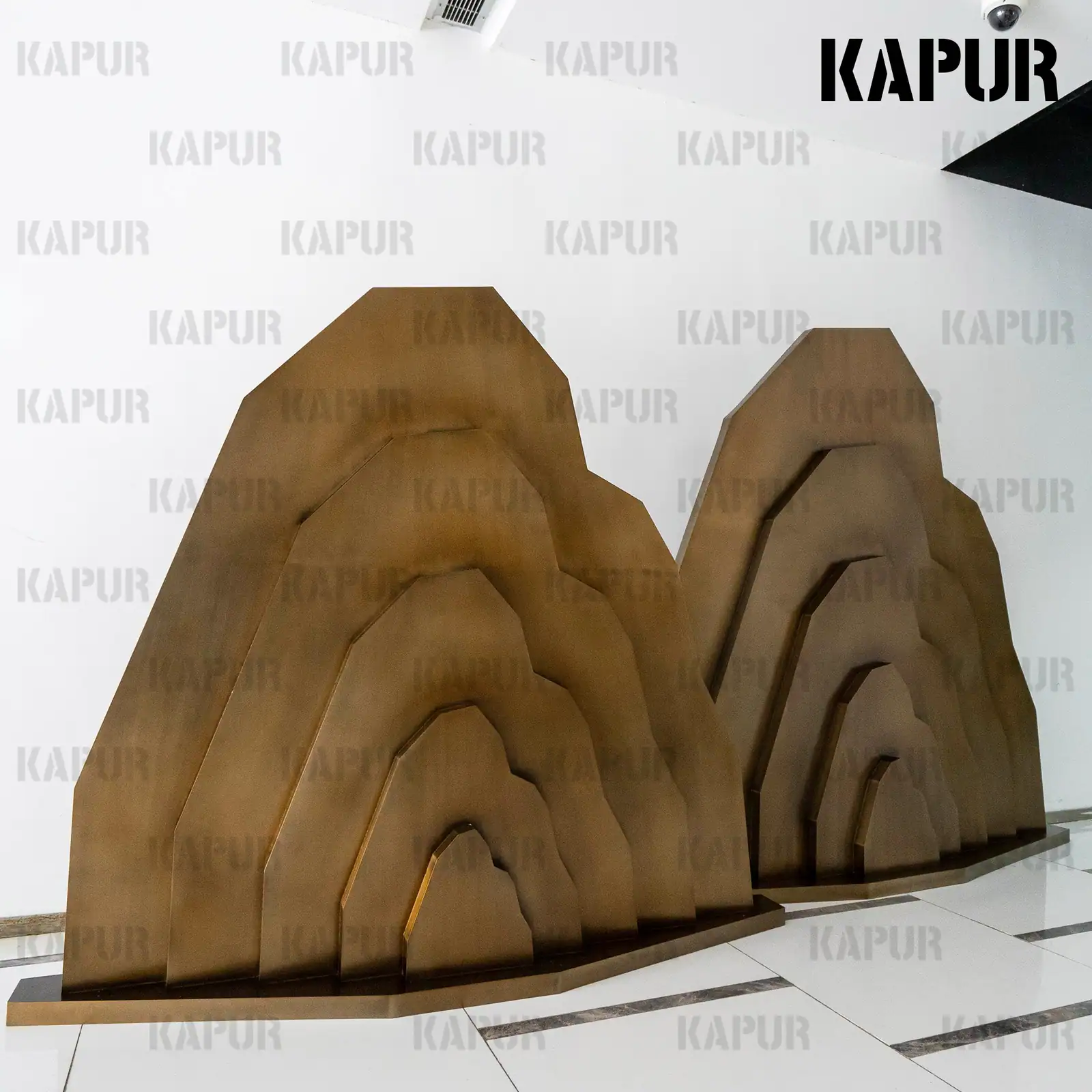 Side view of a custom stainless steel rockery sculpture showing the polished surface and organic form
