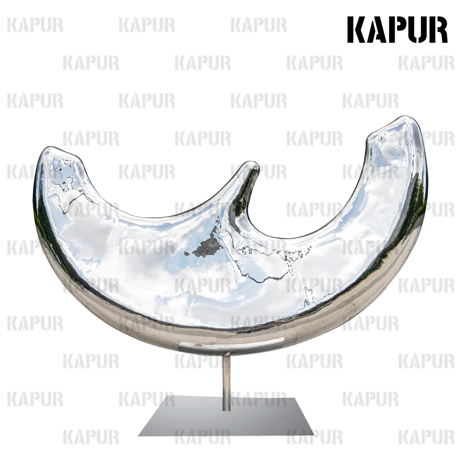 Polished stainless steel moon-shaped sculpture standing on a paved city plaza with reflective surface catching sunlight