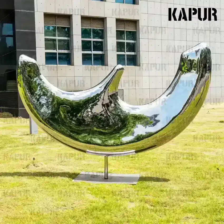 Second view of the moon sculpture showing the smooth curved surface and seamless welds from the side