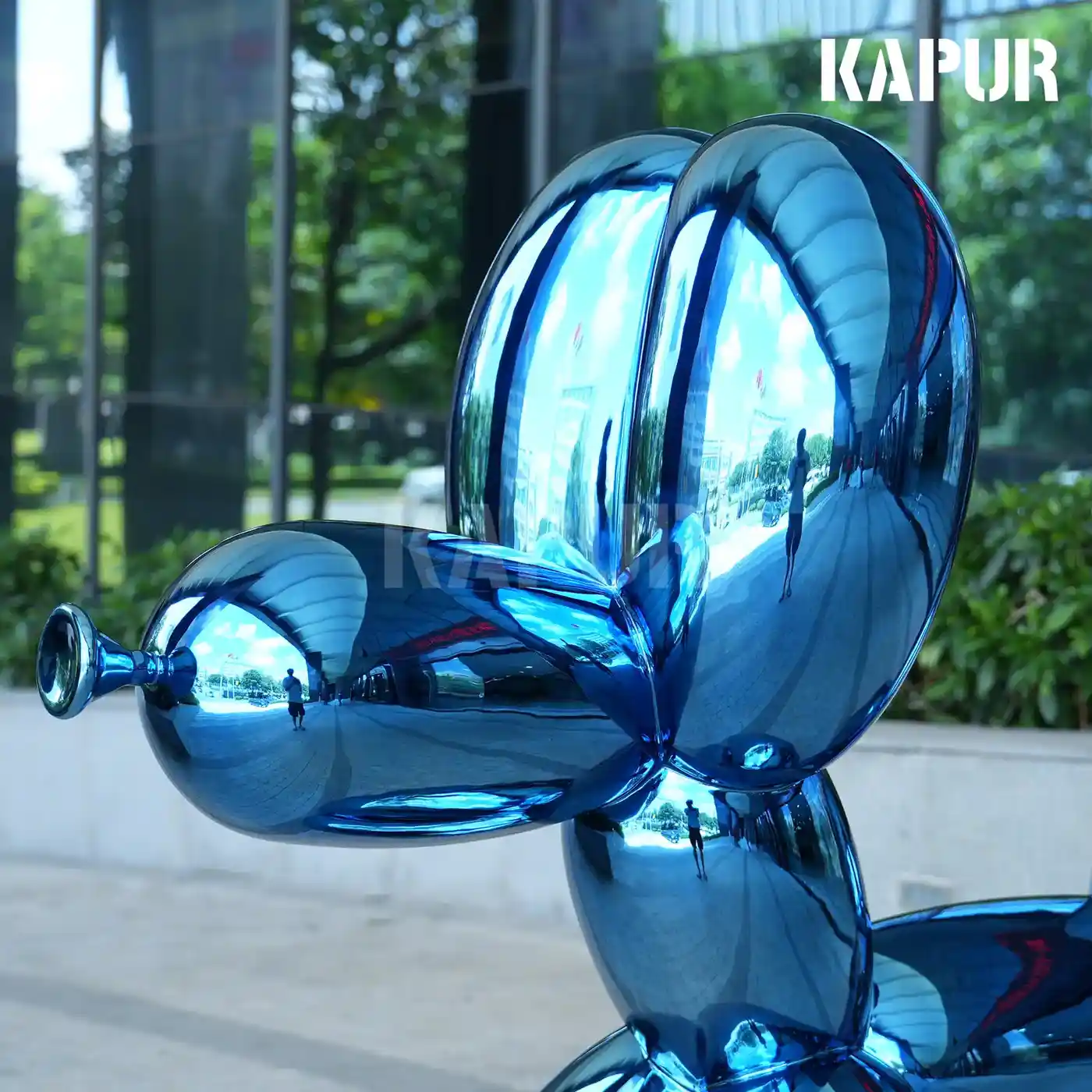 Side view of the super large stainless steel Balloon Dog sculpture showing its reflective curved surface