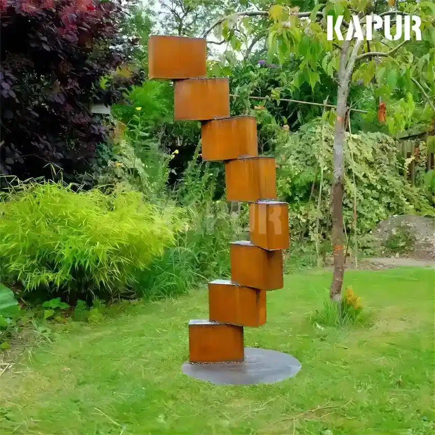Large corten steel garden sculpture in a weathered rust patina standing in an outdoor garden setting