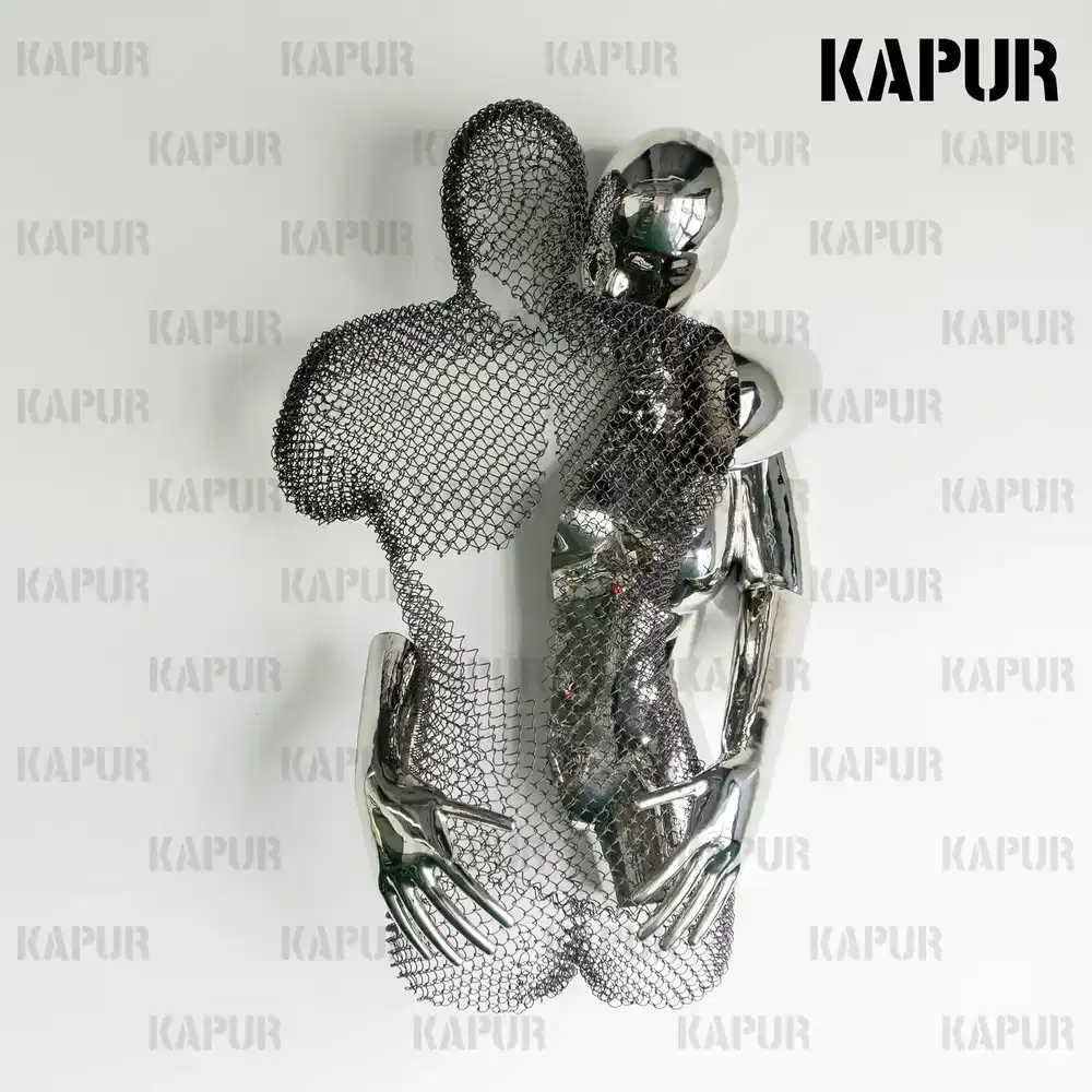 Polished stainless steel abstract human body embrace sculpture standing on a paved outdoor plaza