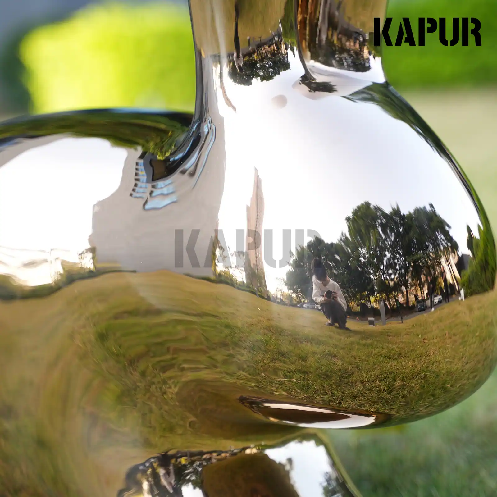 Second view of the stainless steel rabbit sculpture showing the curved reflective surface