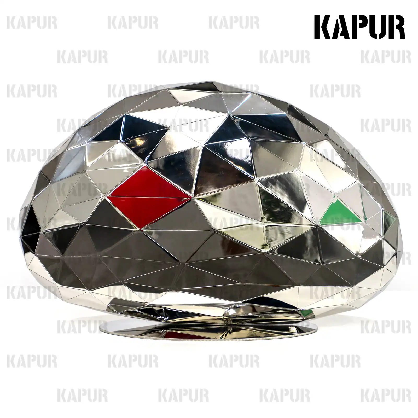 Polished stainless steel geometric sculpture standing on a paved outdoor plaza with reflective surface