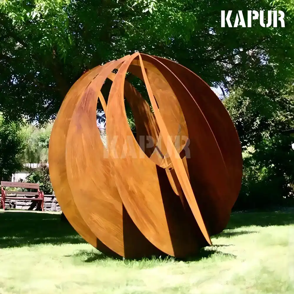 Abstract corten steel spherical sculpture standing in a garden setting with natural planting around it