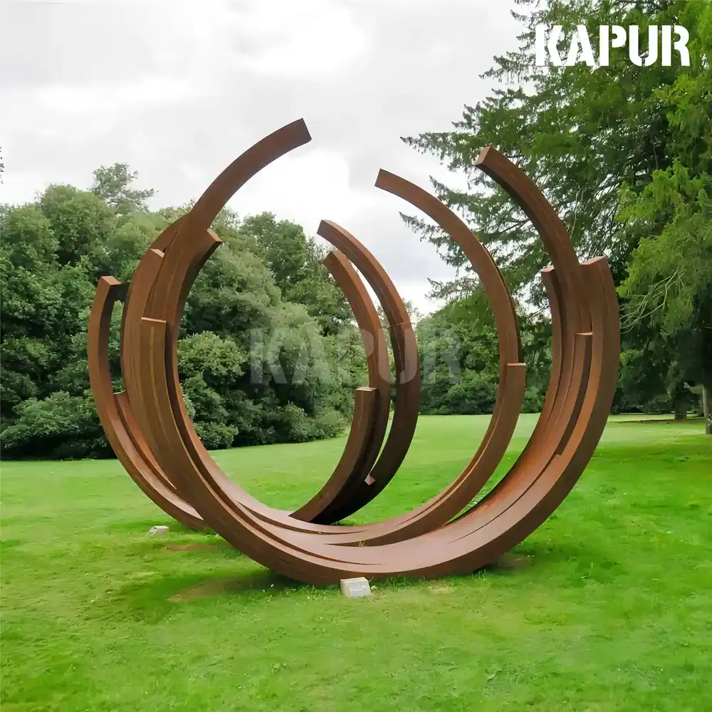 Corten steel interlocking circles sculpture standing on parkland grass
