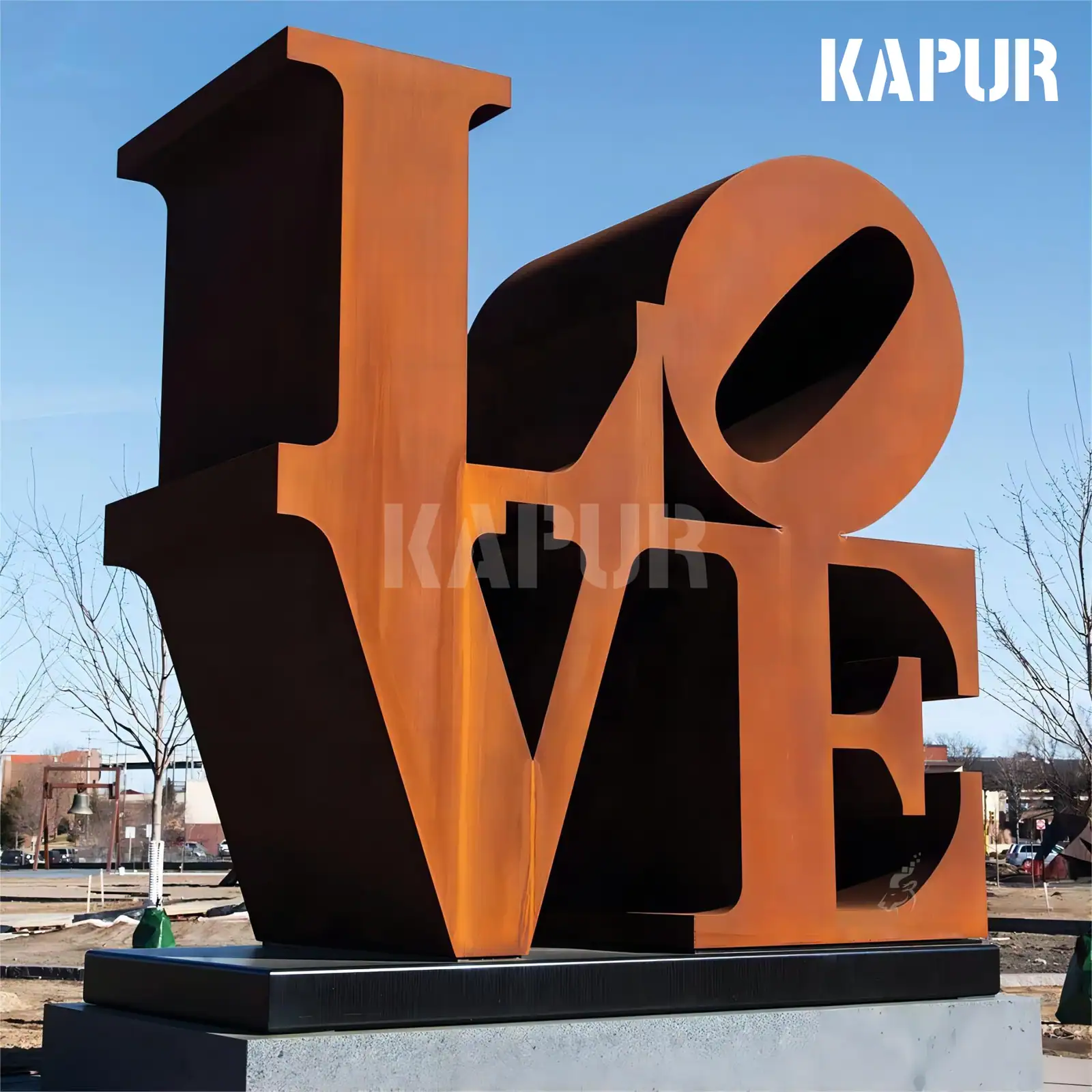 Corten steel LOVE sculpture standing in an outdoor garden with plants and natural surroundings