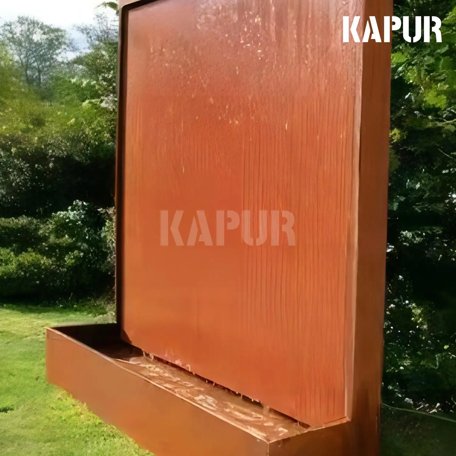Corten steel water wall sculpture in an outdoor garden setting with water flowing down the rusted surface