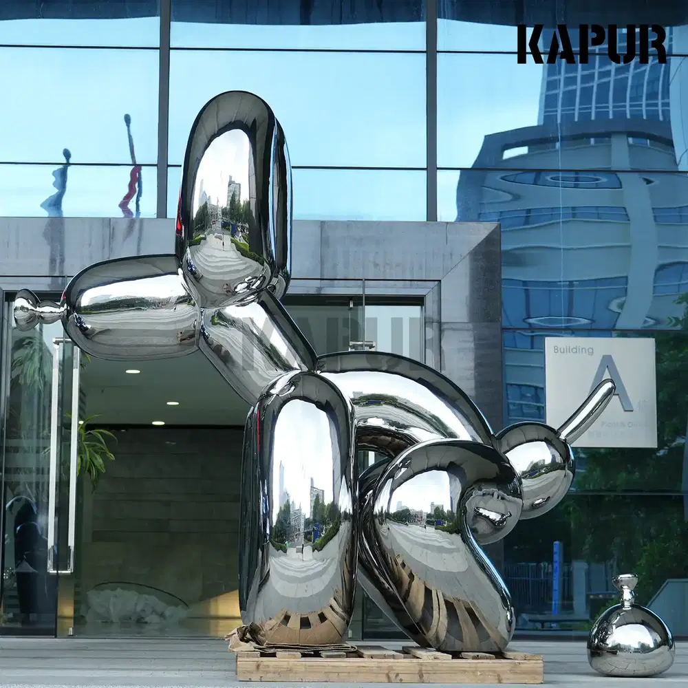 Large stainless steel balloon dog sculpture standing in an outdoor plaza, mirror-polished surface reflecting the sky