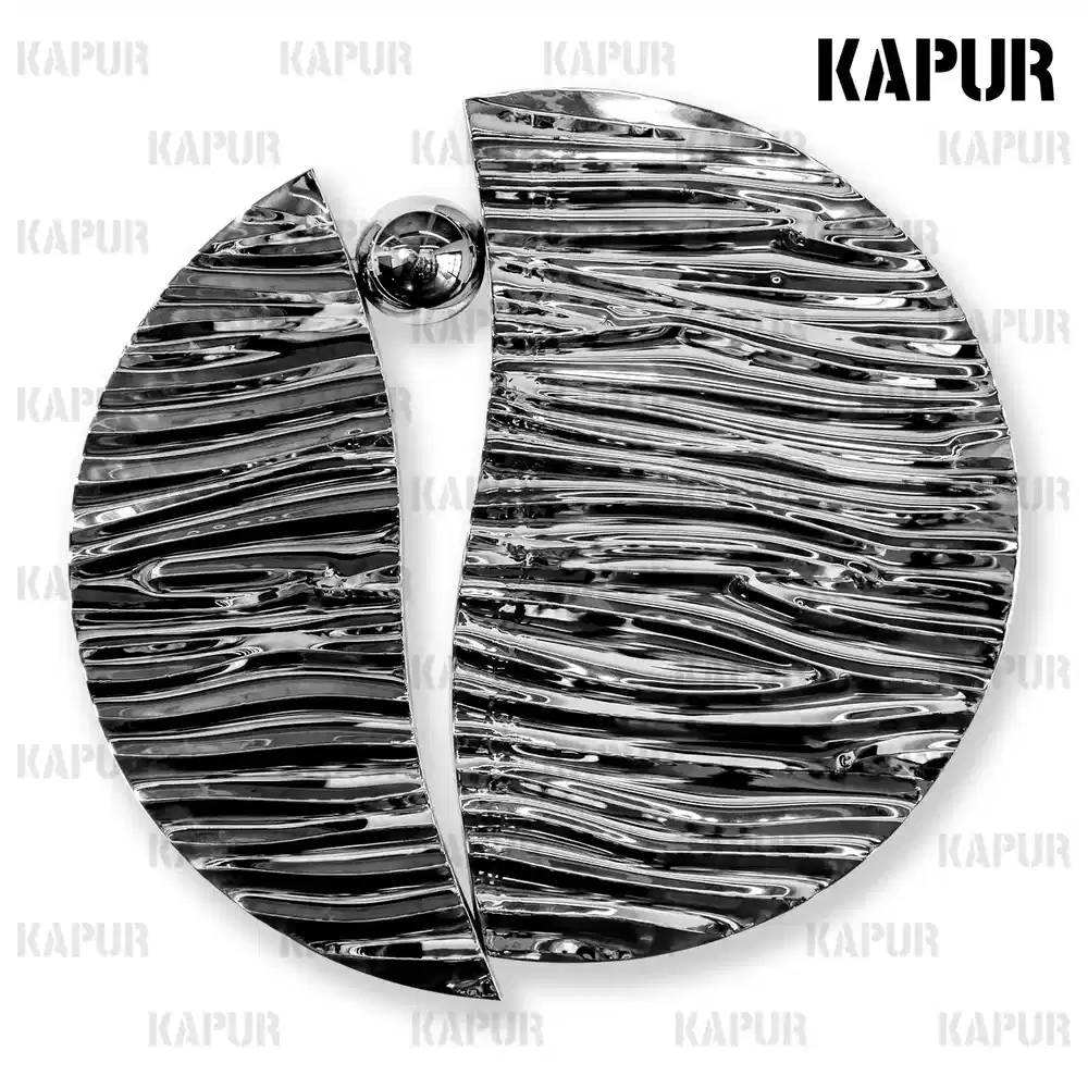 Polished stainless steel water ripple wall sculpture mounted on a white interior wall with soft ambient lighting