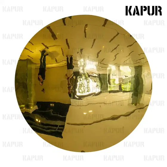 Recessed gold stainless steel mirror wall panel mounted on a white interior wall, reflecting light and surrounding space