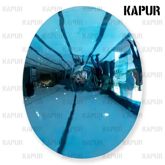 Blue stainless steel mirror oval concave wall decoration mounted on a white interior wall, reflecting light and surrounding space